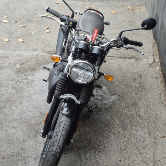 Royal Enfield Interceptor 650 usada 2025, vista frontal detalle faro circular y manillar, negro dorado