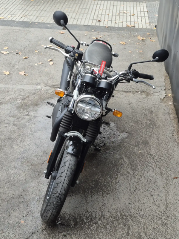 Royal Enfield Interceptor 650 usada 2025, vista frontal detalle faro circular y manillar, negro dorado