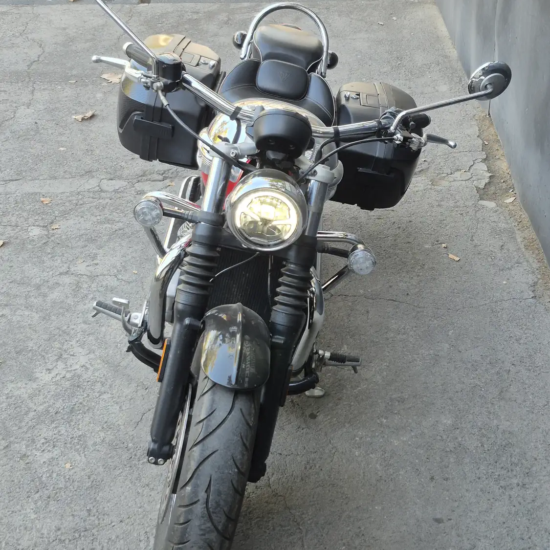 Triumph Speedmaster 1200 2023 frontal directo alforjas laterales rojo negro