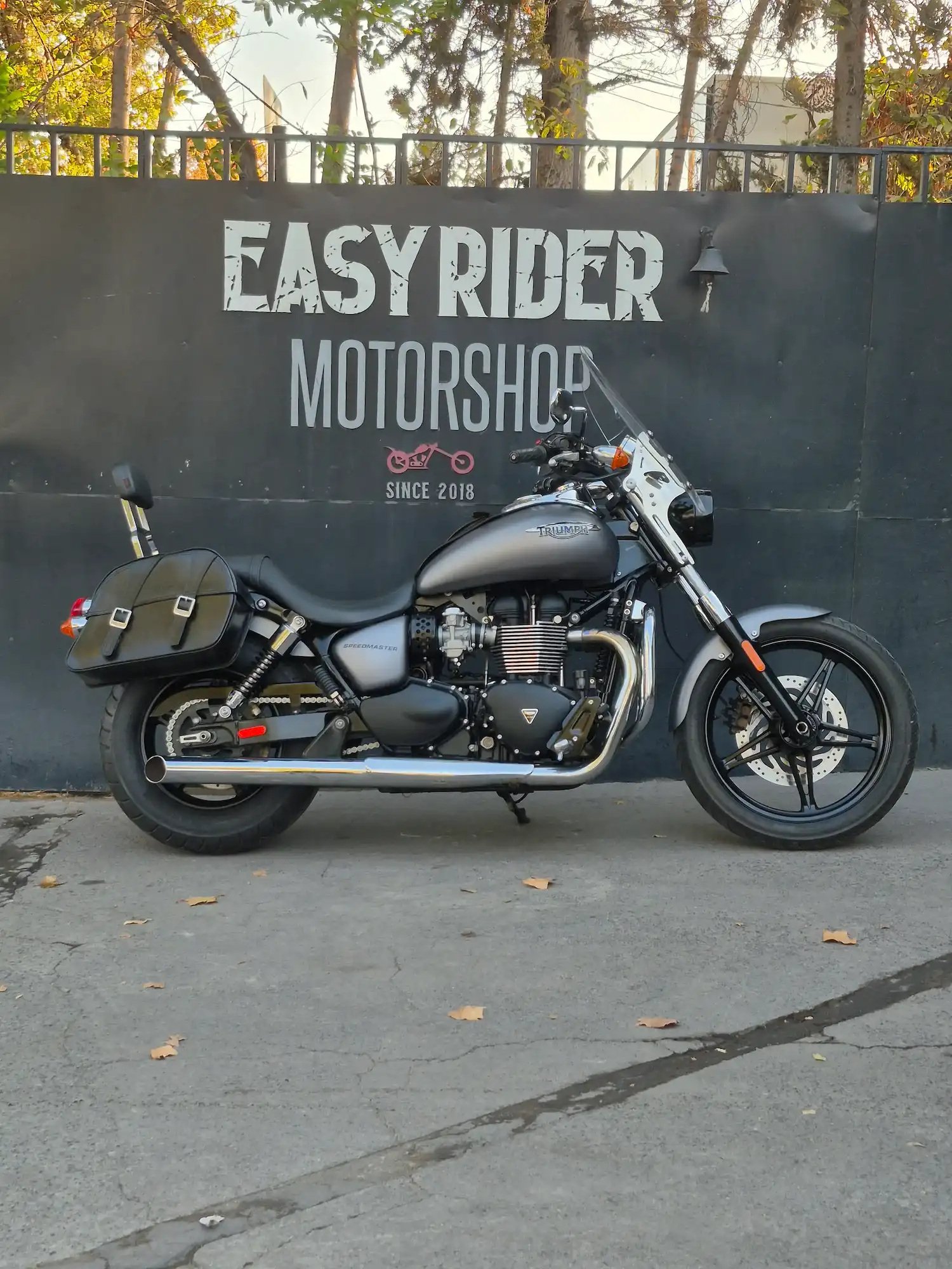 Texto alternativo: Triumph Speedmaster usada 2014 gris grafito perfil lateral con alforjas y parabrisas